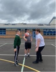 Two pupils playing basketball outside