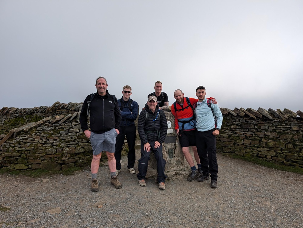 The team stand at the top of one of the peaks