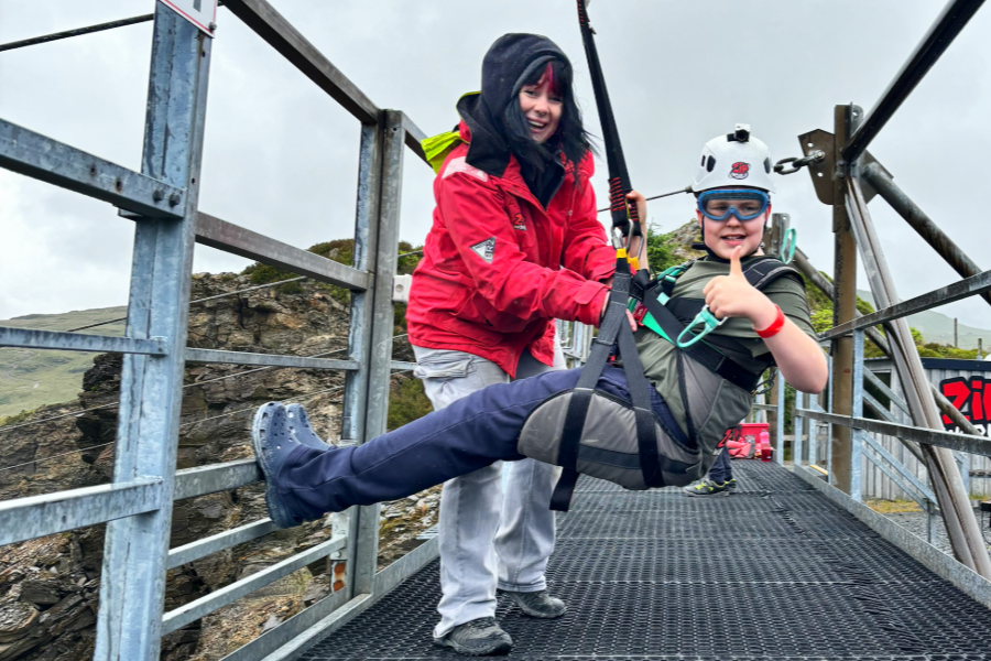 cropped-GFD-Outdoor-Education-1.png pupil giving a thumbs up about to embark on a zip-wire